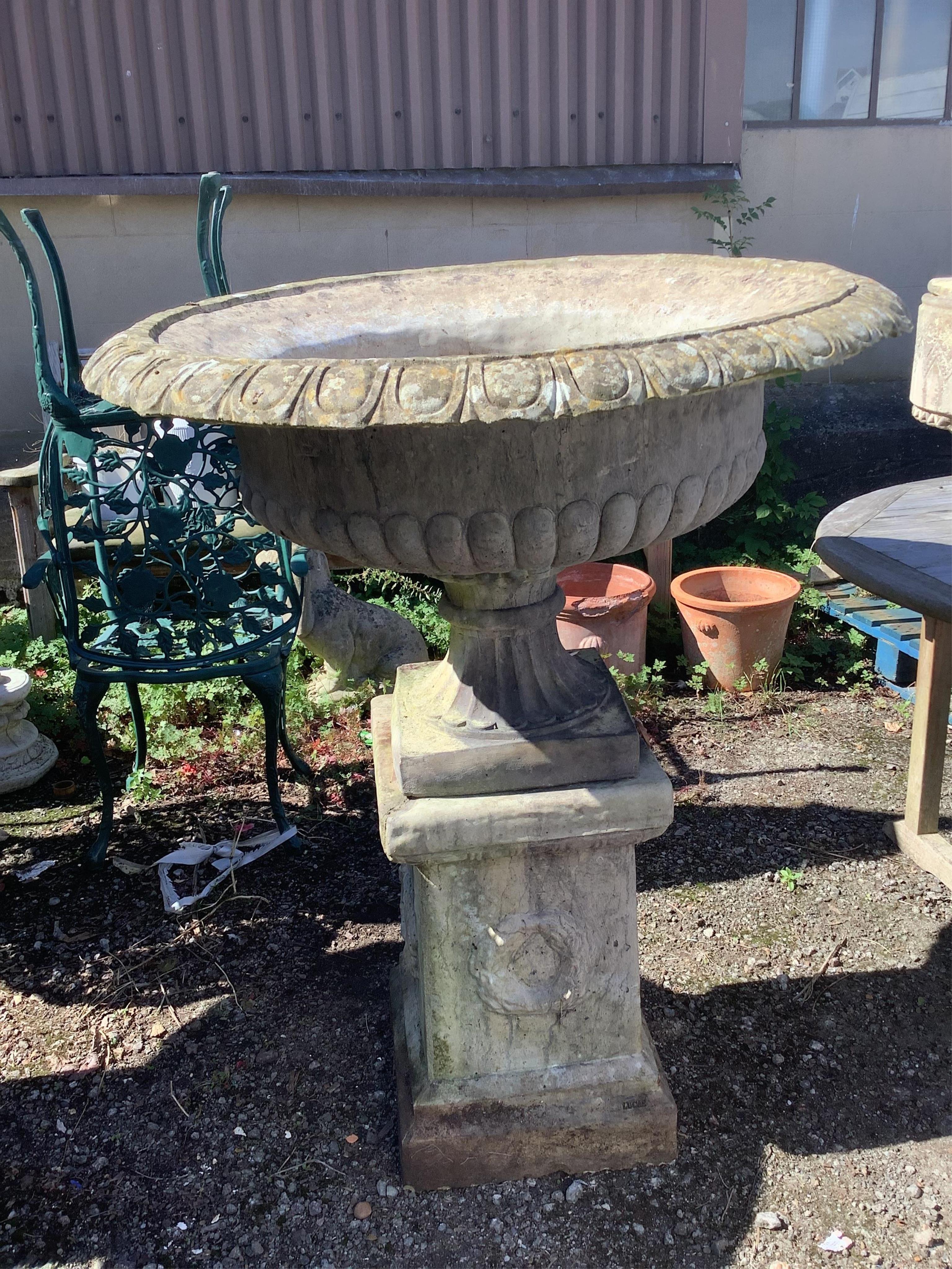 A pair of reconstituted stone campana garden urns on square pedestals, width 94cm, height 116cm. Condition - fair